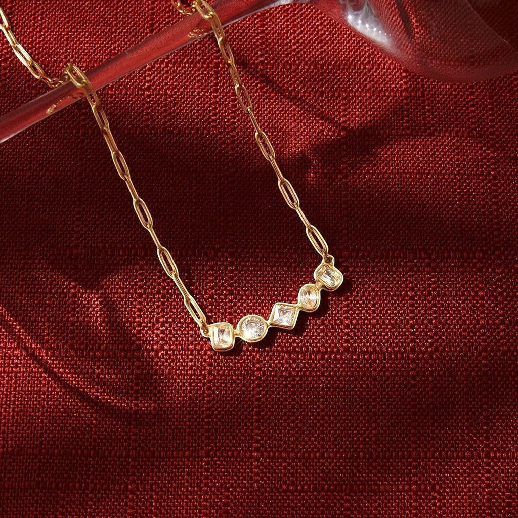 Seraphina Treasures gold-tone necklace with clear round, square, and rectangular gemstones on a delicate chain.