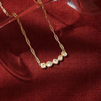Seraphina Treasures gold-tone necklace with clear round, square, and rectangular gemstones on a delicate chain.