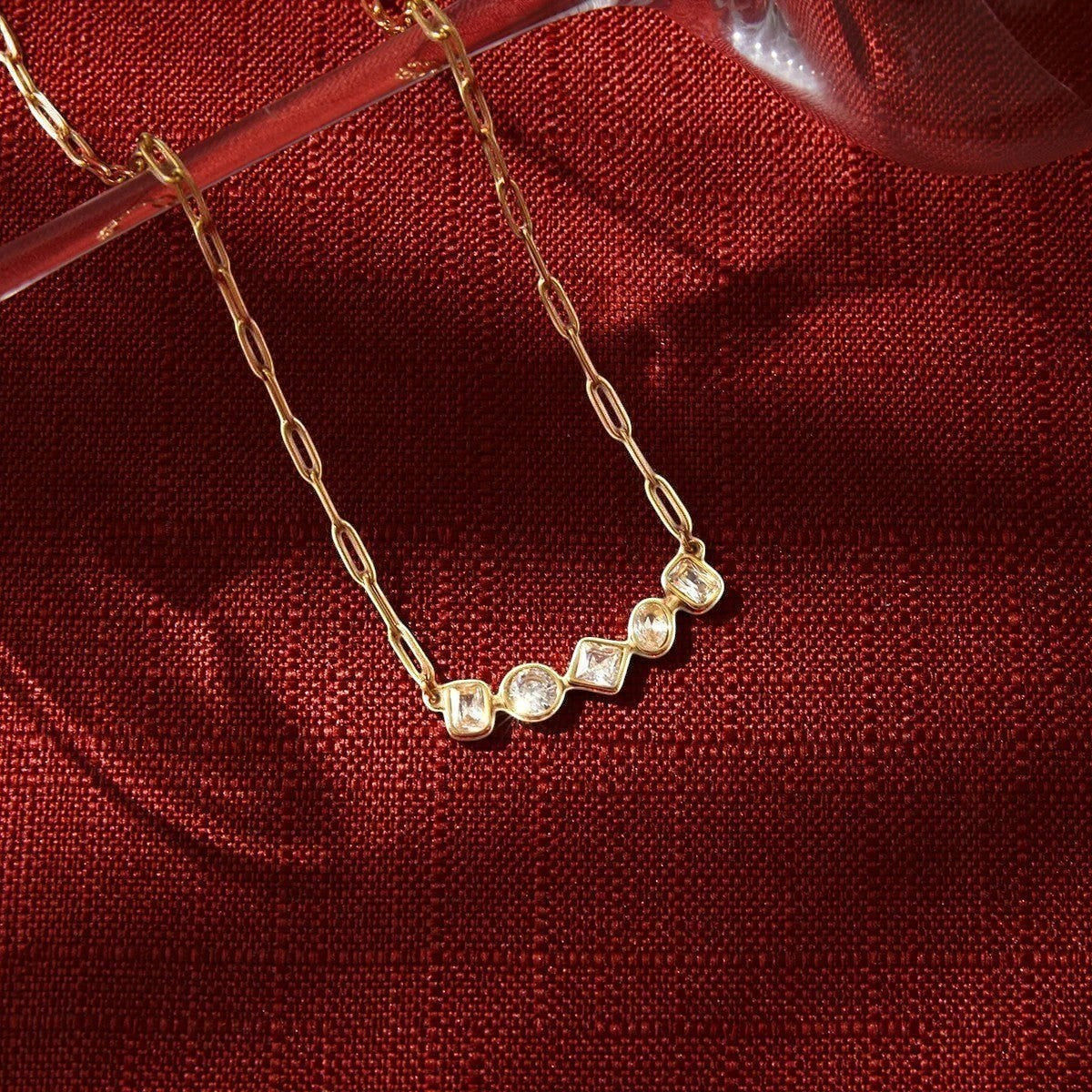 Seraphina Treasures gold-tone necklace with clear round, square, and rectangular gemstones on a delicate chain.