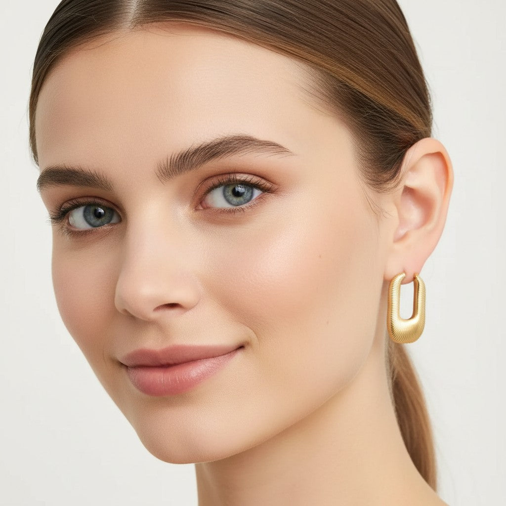 Seraphina Treasures Aelinor gold-tone U-shaped earrings with ribbed detail, worn by a model.