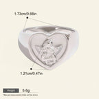 Seraphina Treasures Aetheris ring with a heart-shaped face featuring an angel motif. Silver-tone metal.