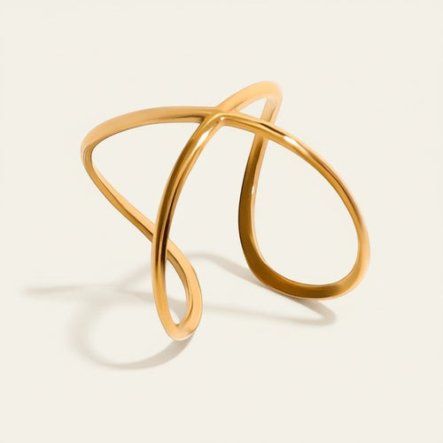 Seraphina Treasures Alcyone gold-tone metal cuff bracelet with an abstract, intertwined design.