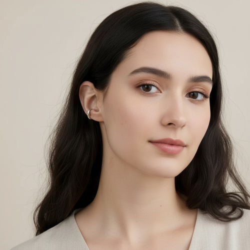 Seraphina Treasures Allegra ear clip, a silver hoop with a gold accent, worn on a woman's ear.
