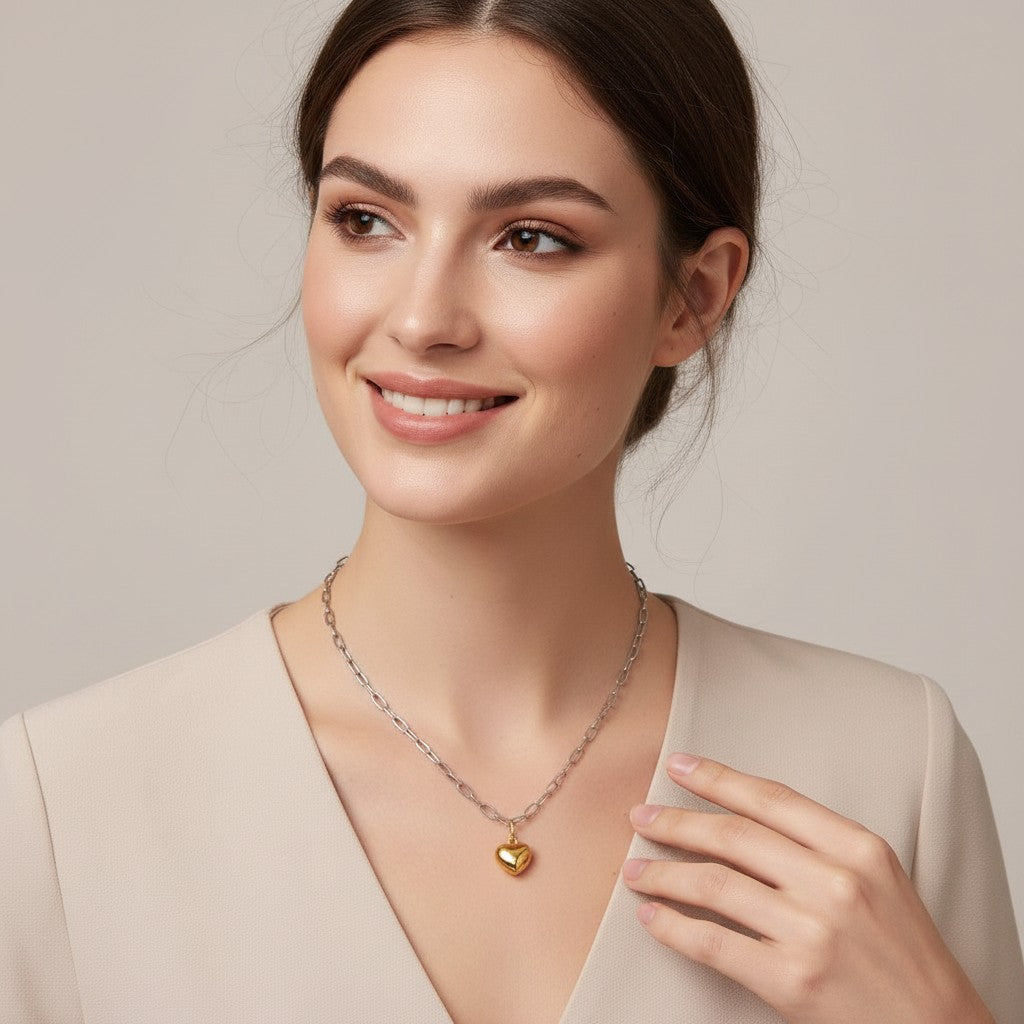 Seraphina Treasures Aureline necklace with a gold heart pendant on a silver chain, worn by a model.