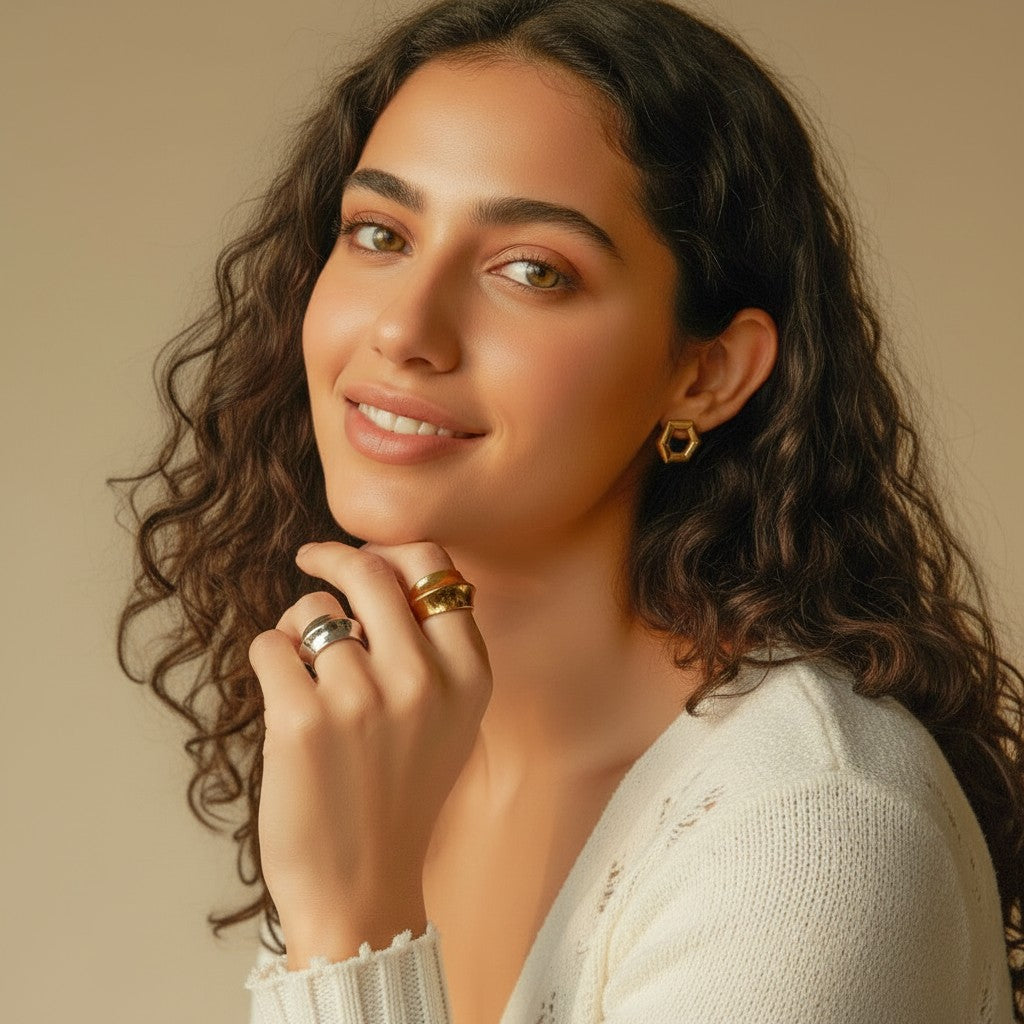 Seraphina Treasures Azura gold ring with concave and convex shapes, worn by a model with curly dark hair.