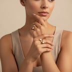 Seraphina Treasures Calyra gold ring with two white mother-of-pearl stones on a woman's hand.