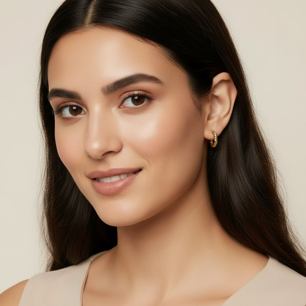 Seraphina Treasures Cassira gold twist hoop earrings on a model.