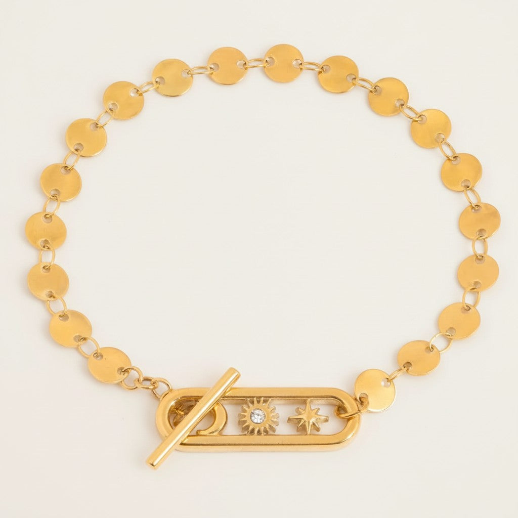 Seraphina Treasures gold-tone bracelet with moon, sun, and star charms and a toggle clasp. Celestial-inspired.