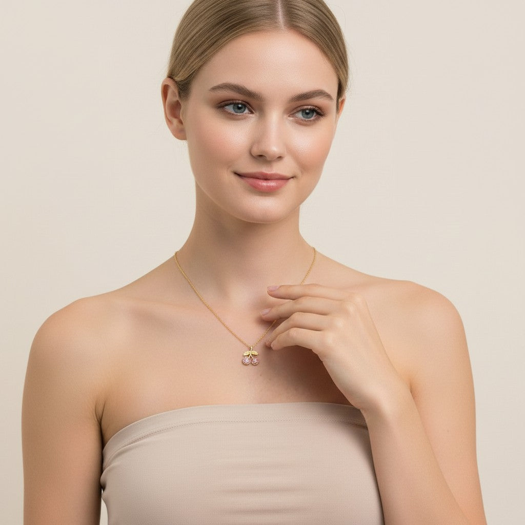 Seraphina Treasures gold necklace with a cherry pendant adorned with pink zirconia stones.