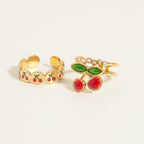 Seraphina Treasures gold rings with cherry design and zirconia stones. Adjustable open bands.