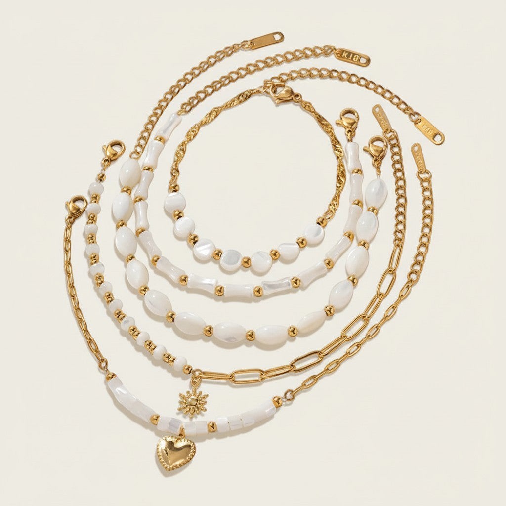 Seraphina Treasures Delia bracelet set with white shells and gold beads, featuring heart and sun charms.