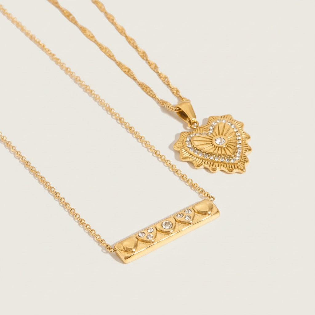 Seraphina Treasures Eirene gold necklaces: one heart pendant with zircon, one bar pendant with heart details and zircon.