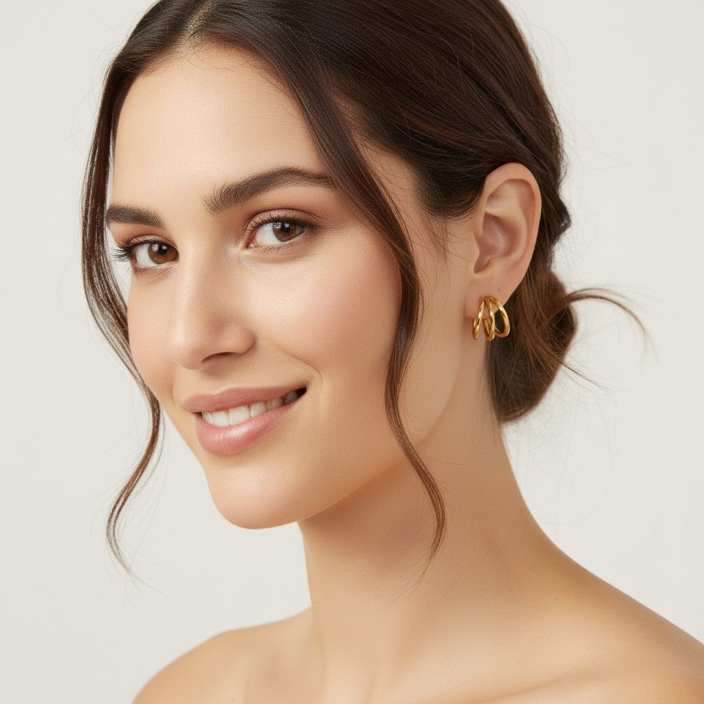 Seraphina Treasures Elidyr gold triple hoop earrings with a shiny finish, worn by a model.