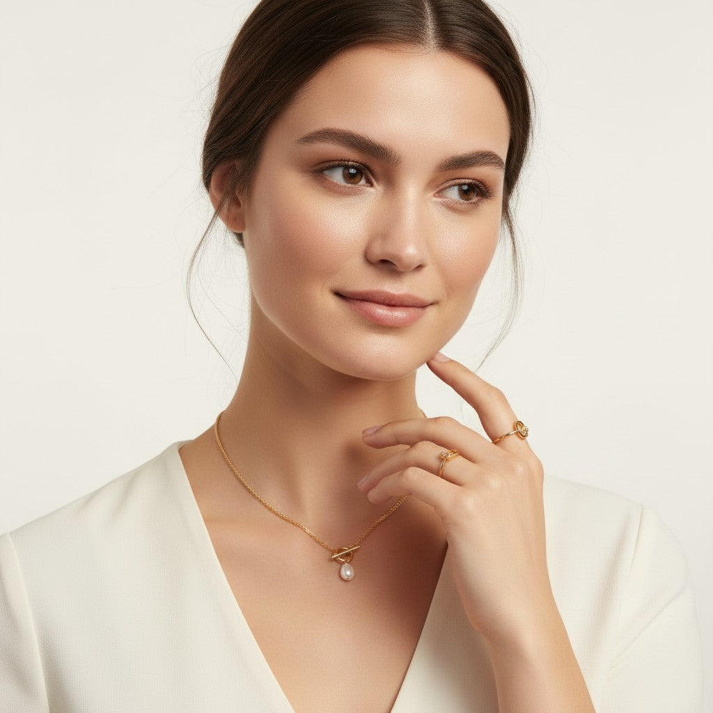 Seraphina Treasures Emberlyn necklace with a single pearl pendant on a gold chain, worn by a model.