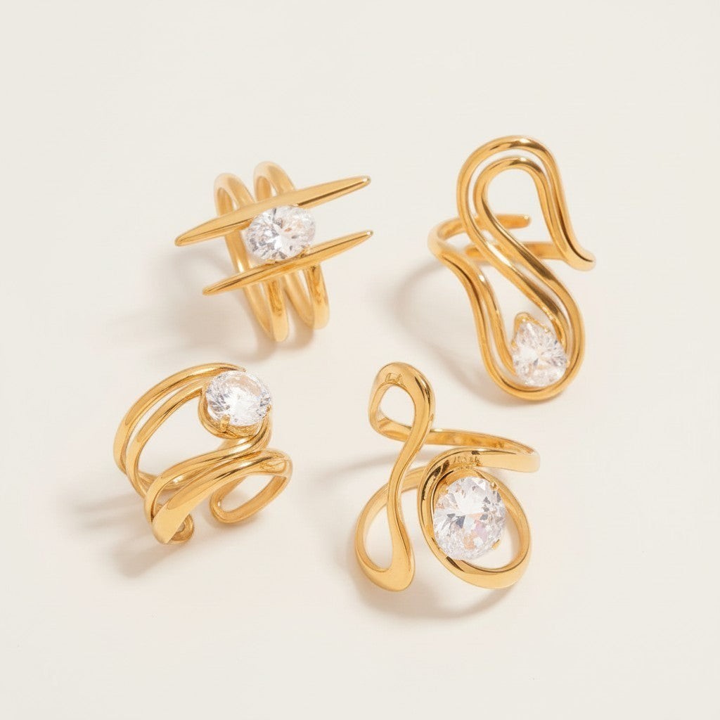Seraphina Treasures Emerya Rings: Set of 4 gold-tone rings with clear cubic zirconia stones, featuring unique abstract and geometric designs.