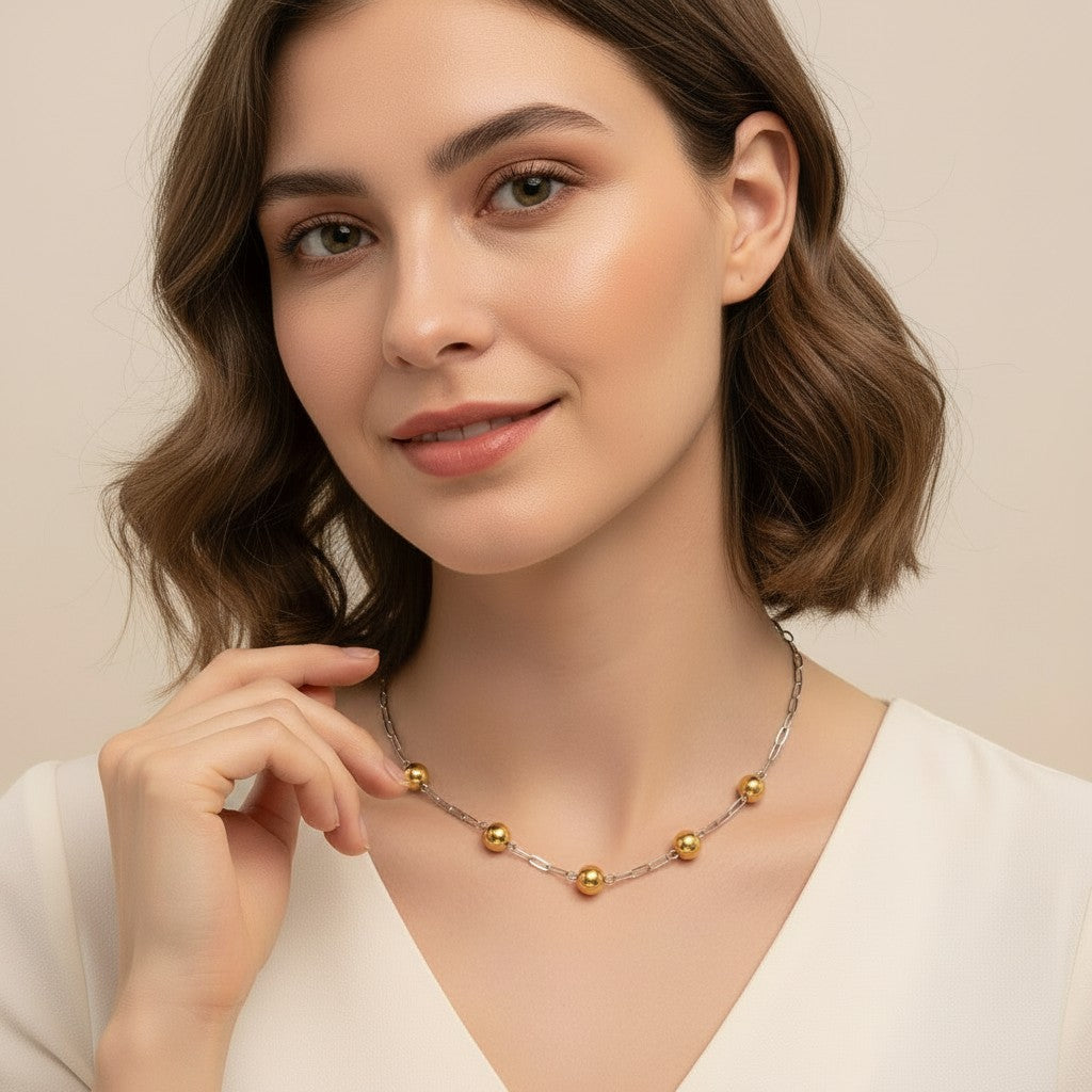 Seraphina Treasures Eosphor necklace with gold spheres and mixed metal chain, worn by a woman.