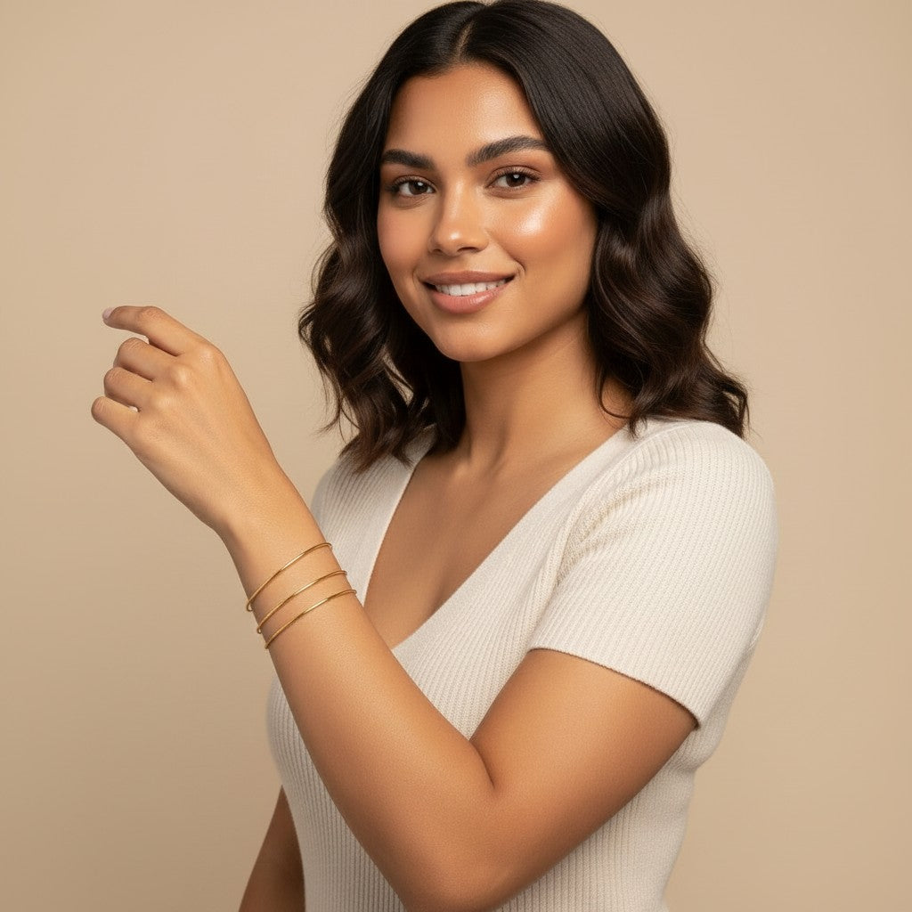 Seraphina Treasures Eulalia gold-tone bangle set with three thin, delicate bands worn on a woman's wrist.