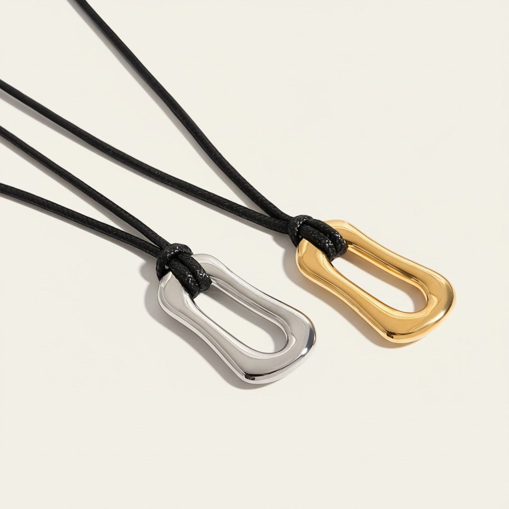 Seraphina Treasures Felicia necklace with asymmetric gold and silver pendants on black wax rope.