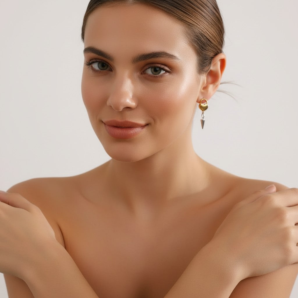 Seraphina Treasures Glyria earrings with gold heart lock and silver cone pendant. Edgy, playful, mixed-metal design.