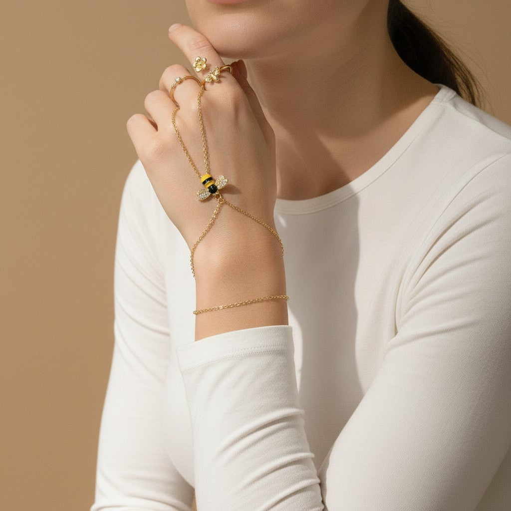 Seraphina Treasures gold bracelet connected to a ring, featuring a bee motif with zircon accents and yellow enamel.