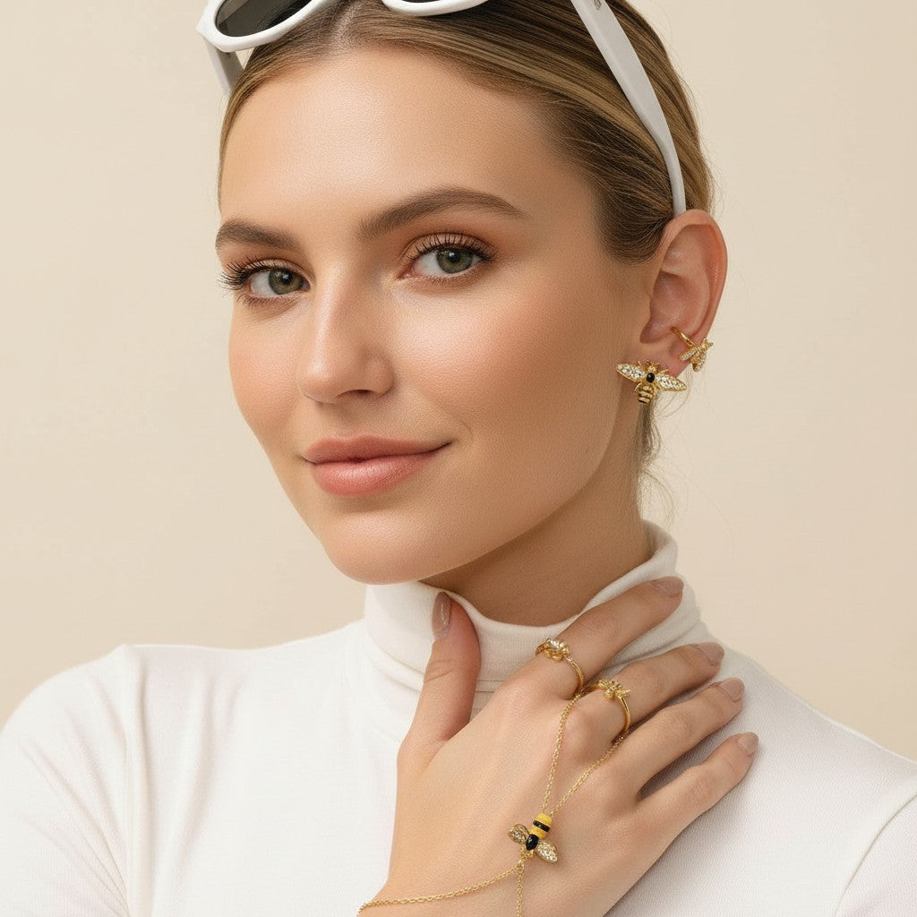 Seraphina Treasures gold bracelet connected to a ring, featuring a bee motif with zircon accents and a small heart charm.