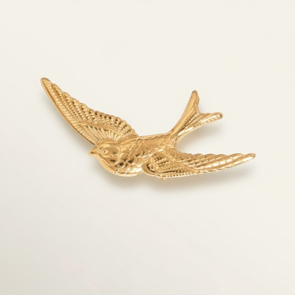 Seraphina Treasures gold-tone metal flying bird hair clip with intricate feather detail.
