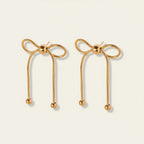 Seraphina Treasures gold bow drop earrings with bead details. Elegant and delicate design.