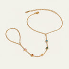 Seraphina Treasures gold chain bracelet with colorful zircon accents, connecting to a finger loop.