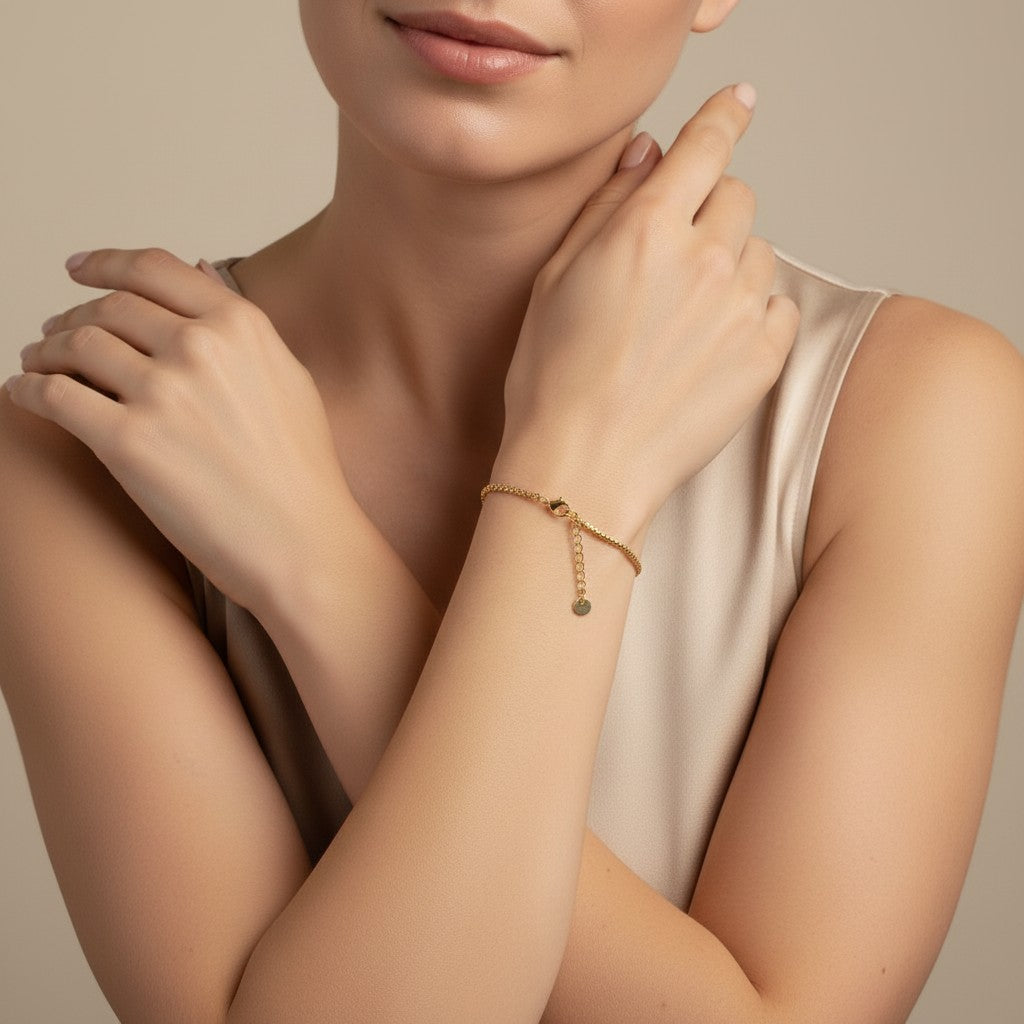 Seraphina Treasures gold chain bracelet with a small disc charm, worn by a model.