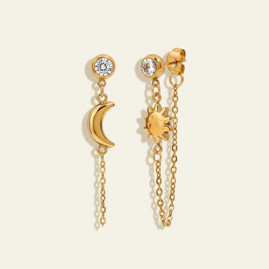 Seraphina Treasures gold celestial drop earrings with a crescent moon and a sun charm, featuring clear crystal studs.