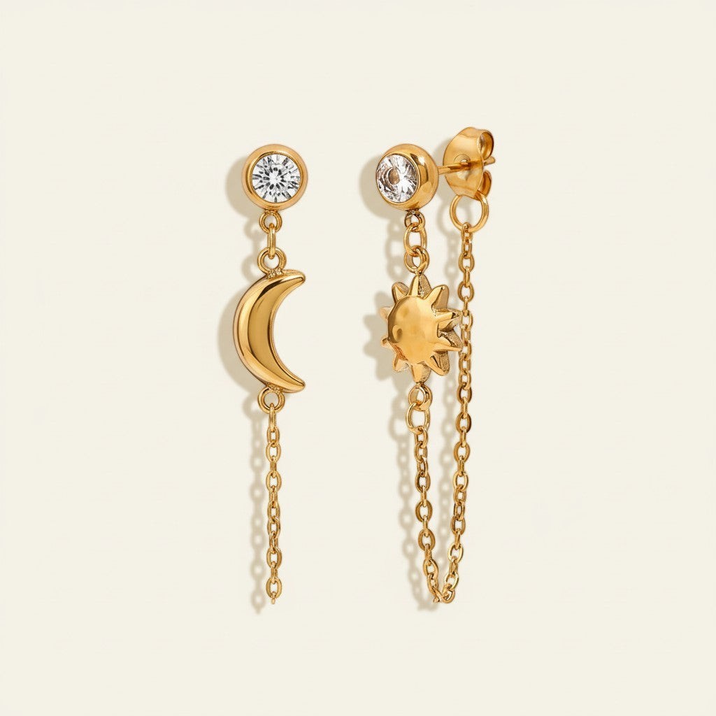 Seraphina Treasures gold celestial drop earrings with a crescent moon and a sun charm, featuring clear crystal studs.