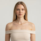 Seraphina Treasures gold necklace with shell, starfish, and zircon charms. Delicate chain with bead accents.
