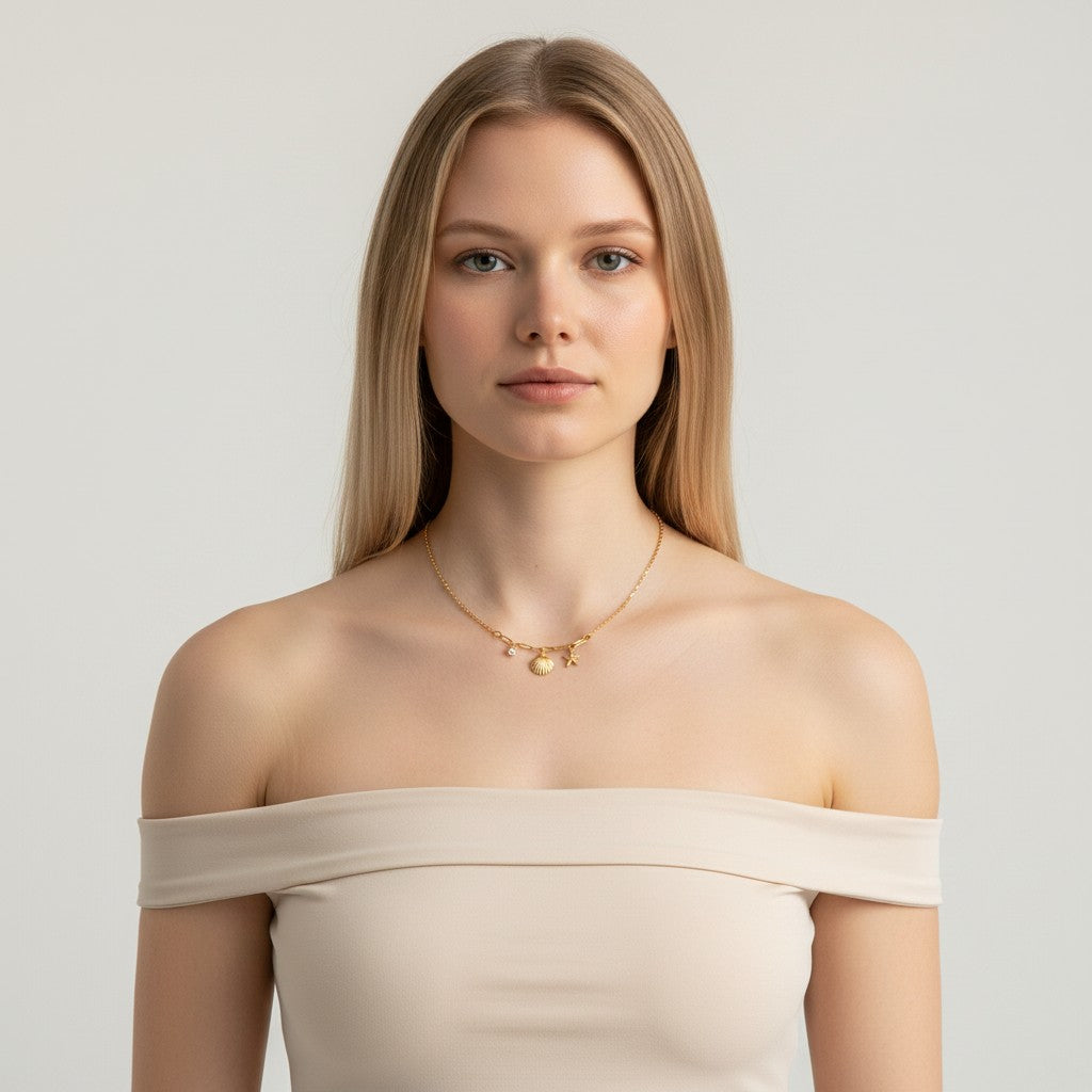 Seraphina Treasures gold necklace with shell, starfish, and zircon charms. Delicate chain with bead accents.