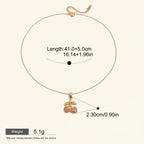 Seraphina Treasures gold necklace with a cherry pendant adorned with pink cubic zirconia stones.
