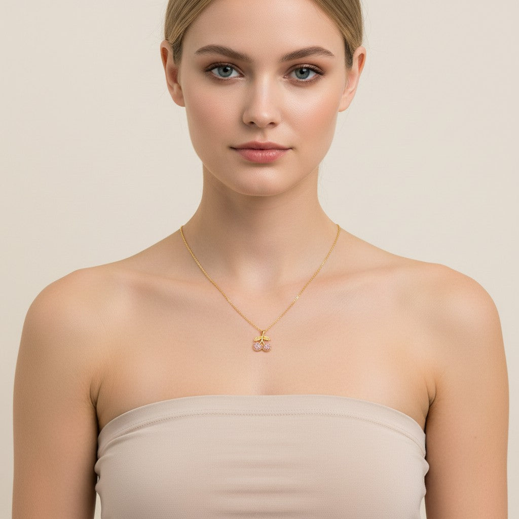 Seraphina Treasures gold necklace with a cherry pendant adorned with pink zirconia stones and delicate leaf details.