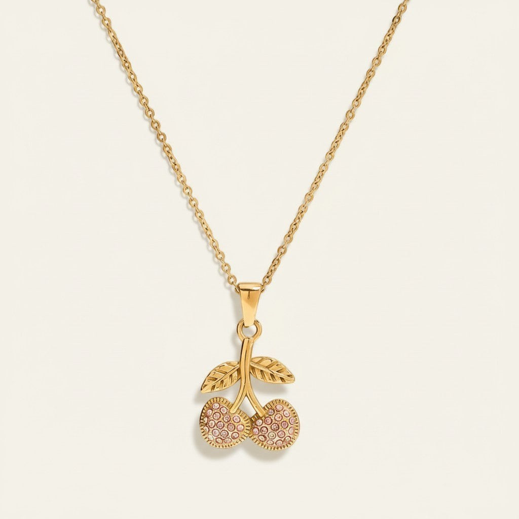 Seraphina Treasures gold necklace with a cherry pendant adorned with pink zirconia stones and delicate leaf details.