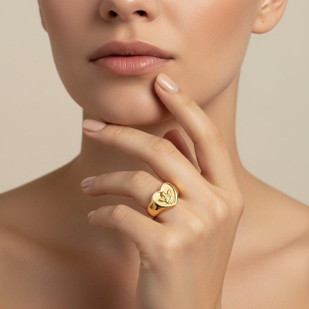 Seraphina Treasures gold heart ring with an embossed cherub design. Symbolizes love and protection.