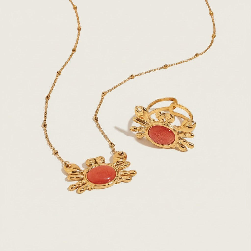 Seraphina Treasures gold crab necklace and ring with red opal stone. Ocean-inspired jewelry.