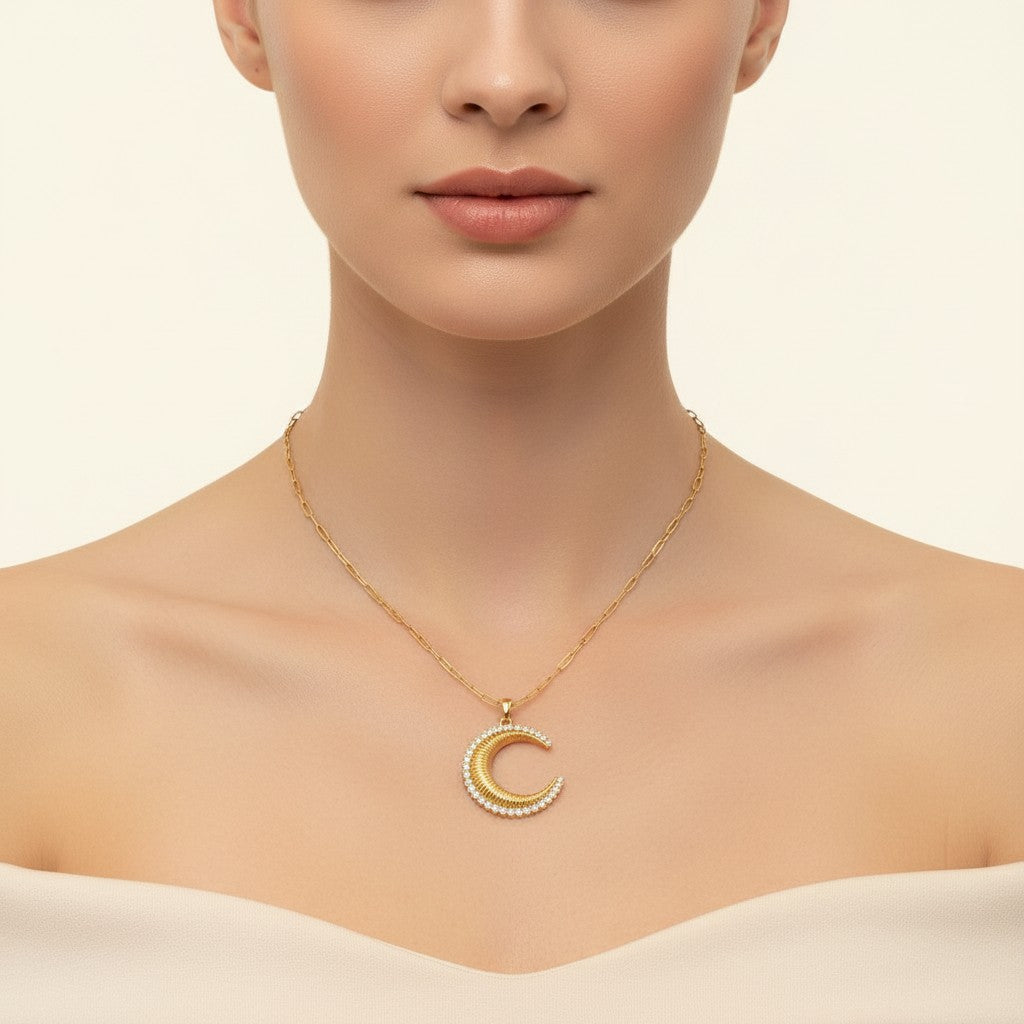 Seraphina Treasures gold-tone necklace with a crescent moon pendant adorned with clear zirconia stones. Paperclip chain with adjustable length.