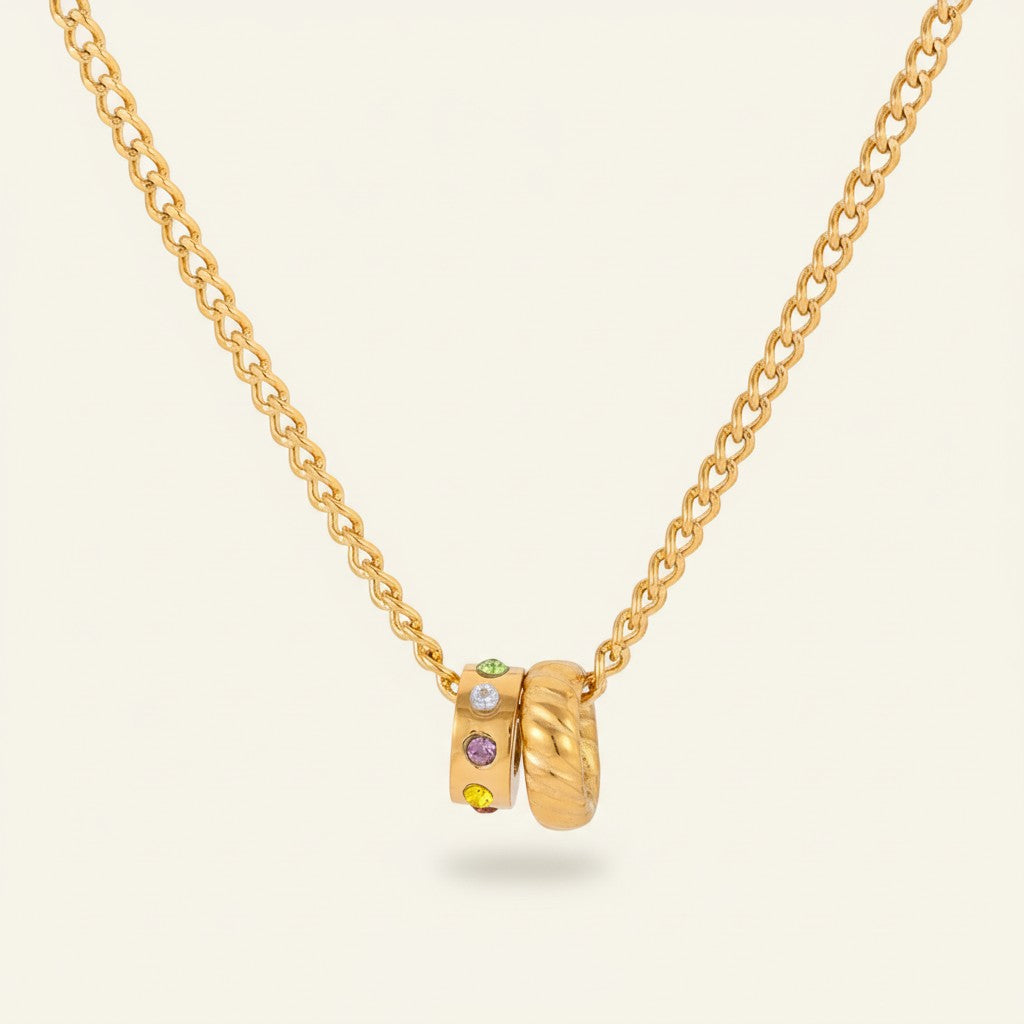 Seraphina Treasures gold necklace with two interlocking pendants, one with multi-colored crystals.