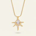 Seraphina Treasures gold necklace with a teardrop cubic zirconia pendant surrounded by starburst rays and small clear stones.