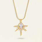 Seraphina Treasures gold necklace with a teardrop cubic zirconia pendant surrounded by starburst rays and small clear stones.
