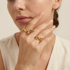 Seraphina Treasures gold dachshund ring with zirconia eye and gold cat ring on a woman's hand.