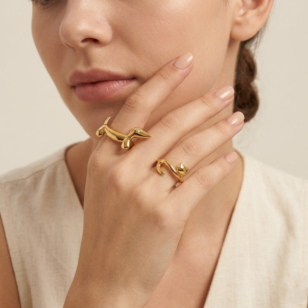Seraphina Treasures gold dachshund ring with zirconia eye and gold cat ring on a woman's hand.