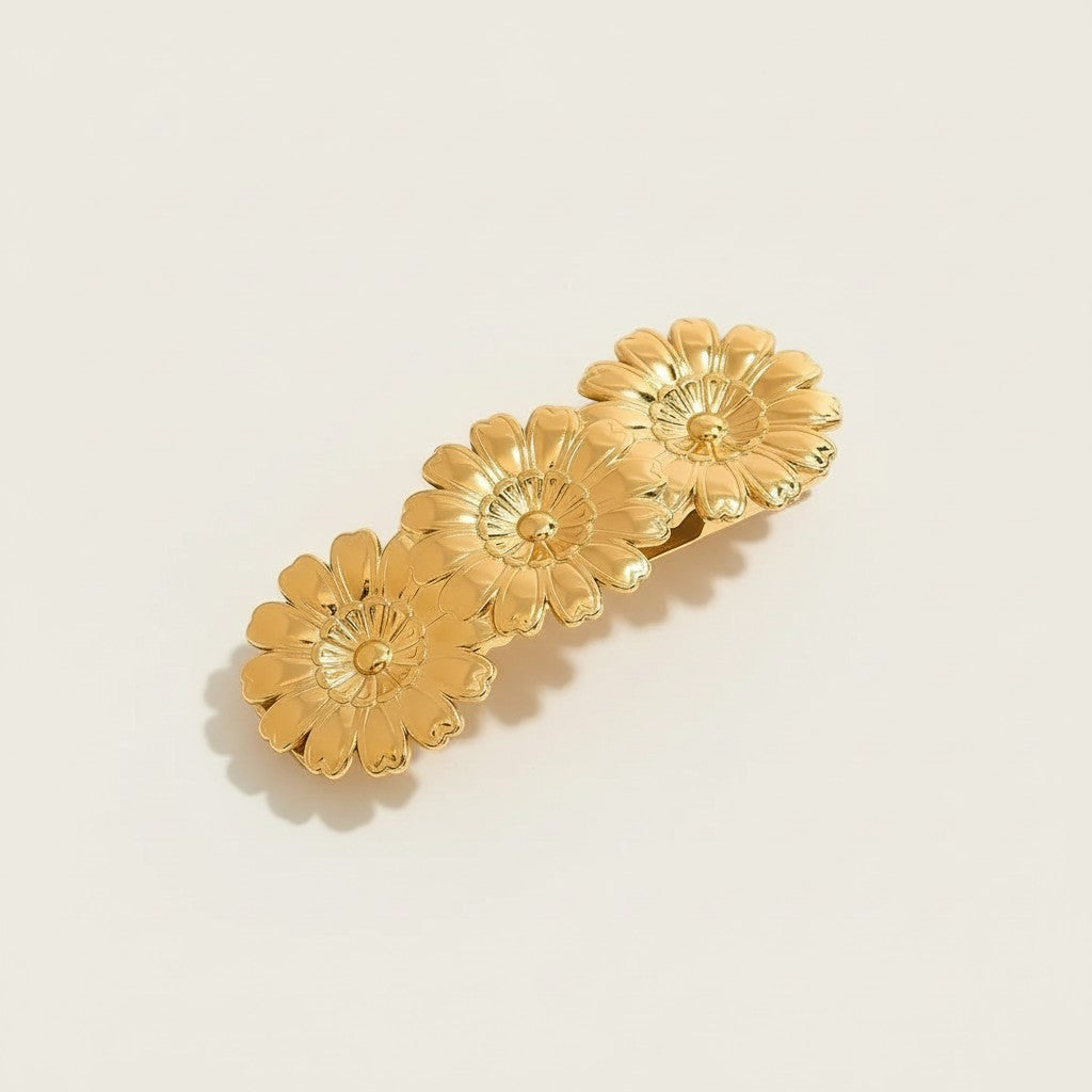 Seraphina Treasures gold-tone metal barrette with three embossed daisy flowers, glossy finish.