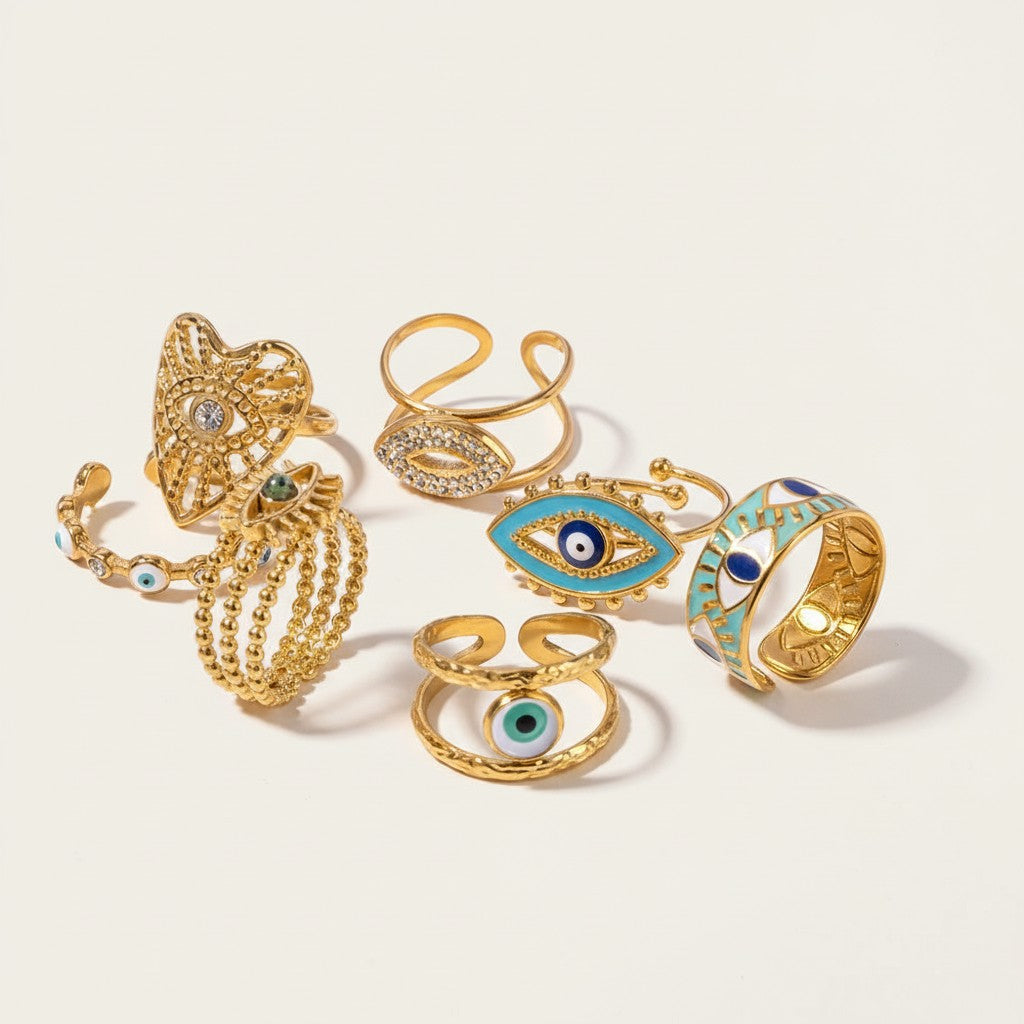 Seraphina Treasures gold-tone rings with evil eye motifs, some with blue enamel and crystals.