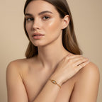 Seraphina Treasures Myrrha gold-tone bracelet with a clear zircon eye centerpiece, worn on a woman's wrist.