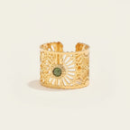 Seraphina Treasures gold-tone open ring with intricate filigree design and a central green stone. Adjustable.