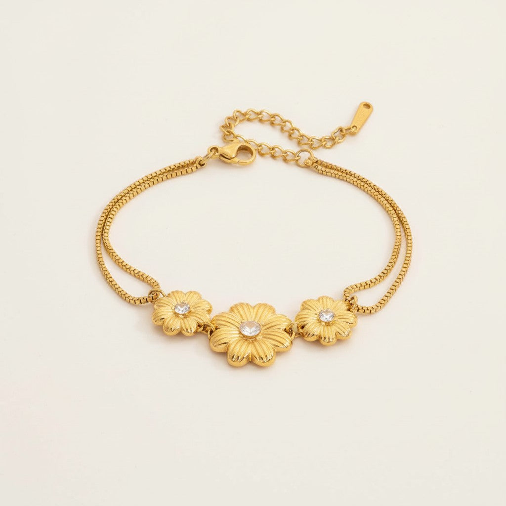 Seraphina Treasures gold-tone bracelet with three floral charms, each featuring a cubic zirconia center. Delicate double chains.