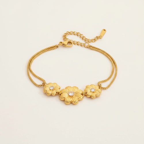 Seraphina Treasures gold-tone bracelet with three floral charms, each featuring a cubic zirconia center. Delicate double chains.